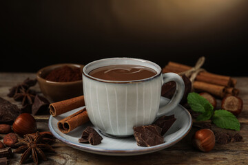 Composition with yummy hot chocolate in cup on wooden table