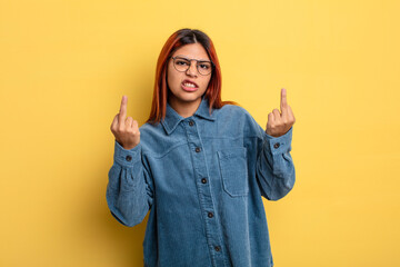 young hispanic woman feeling provocative, aggressive and obscene, flipping the middle finger, with...