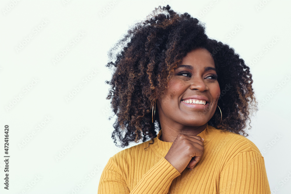 Wall mural Portrait of a happy young woman smiling dressed in a yellow shirt, looking right