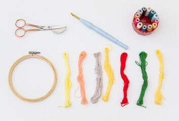 Rounded scissors, punch needle,hoop, floss and thread. Embroidery tools. Needlework