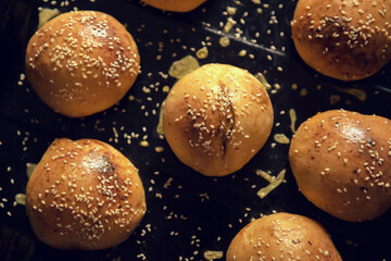 Delicious sesame buns on a dark background. Freshly Baked Buns. Hamburger buns are hot, fresh from the oven. Homemade hamburger buns with brioche buns. culinary experience. background