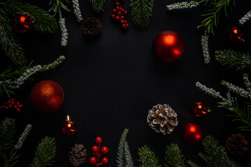 Fototapeta na wymiar Christmas background with fir branches and red ball on dark and black background. Top view with copy space