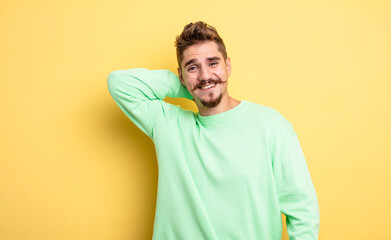 young handsome man laughing cheerfully and confidently with a casual, happy, friendly smile....