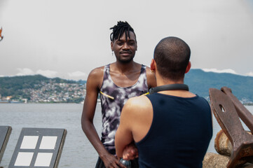 Black african athlete and her friend talking in the park on sunny day, in the background beautiful...