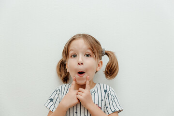 Little cute girl with big beautiful eyes. Studio shot, white background, minimalism. Facial...