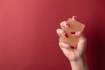 Hand grabbing soap over red copy space