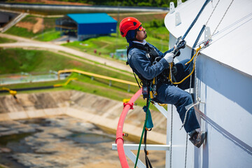 Male worker down height tank roof rope access safety inspection of thickness storage tank gas