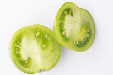 sliced green tomato on white background
