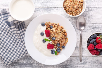 Healthy breakfast with baked granola and greek yogurt. Assorted fresh berries