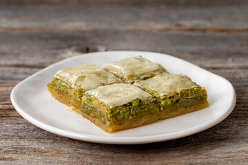 Pistachio baklava on a wooden background. Turkish style pistachio baklava presentation and service. Horizontal view. close up