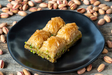 Pistachio baklava on a wooden background. Turkish style pistachio baklava presentation and service. Horizontal view. close up
