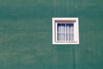 White window on an old green stucco wall as background
