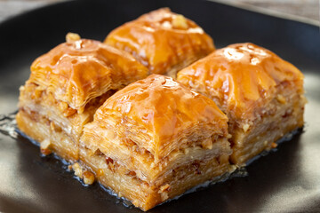 Walnut Baklava on wooden background. Turkish style walnut baklava presentation and service. Horizontal view. close up