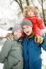 Portrait of happy family with one kid in winter casual outfit