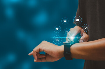 Man hand touching a smart watch virtual icon. Communication and use of modern Internet technology...