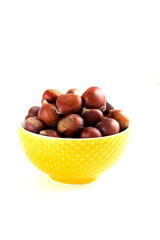 Obraz premium Сhestnuts in a saucer. Сhestnuts in a sauceron white background. Сhestnuts in a saucer isolate.