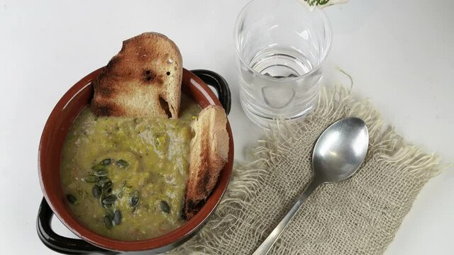 ciotola con zuppa e vino bianco versato nel bicchiere
