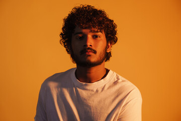 Obraz premium Young bearded man dressed in t-shirt posing and looking at camera