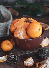 Obraz na płótnie Canvas Ripe bright tangerines in a brown ceramic bowl.