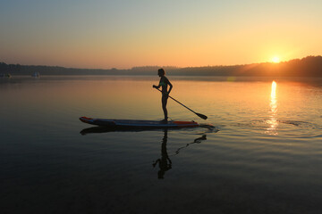 silhouette of a person on a paddleboard at sunrise