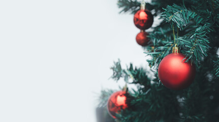 Merry Christmas decoration. Red balls hanging on pine branches Christmas tree garland and ornaments over abstract winter background with copy space for text.