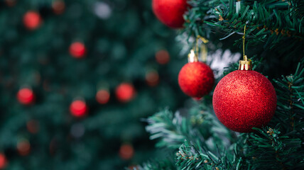 Merry Christmas decoration. Red balls hanging on pine branches Christmas tree garland and ornaments...