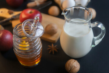 Milk in a glass jug and other ingredients and spices for a birthday cake.