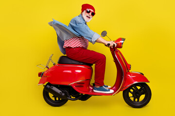 Profile side view portrait of elderly retired pensioner cheery man riding moped isolated over...