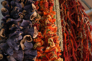 Dried vegetables in the traditional way strung on threads and hung on the street. Dried red hot and sweet peppers.