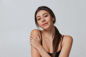 Obraz premium Young adorable girl looking at camera isolated over gray studio background. Natural beauty concept.