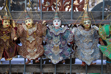 Colorful puppets in a tourist stall on the street market in Burma, Myanmar. Handmade dolls hanging...