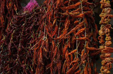 Dried vegetables in the traditional way strung on threads and hung on the street. Dried red hot and sweet peppers.