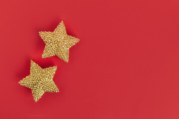 Fototapeta na wymiar Golden sparkle stars on a red background.