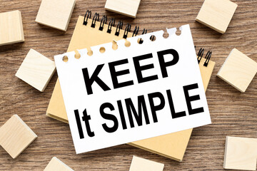 KEEP IT SIMPLE. text on white notepad on wood background