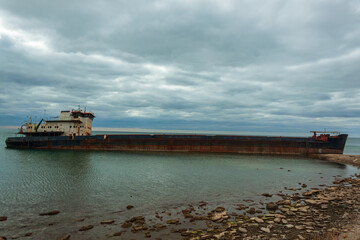 Shipwreck of a dry cargo ship off the coast of the Taman Peninsula. An abandoned rusty vessel on the shoal in the black sea.