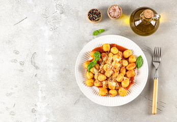 Homemade recipe gnocchi with hot tomato sauce and cheese on a white plate. Potato gnocchi is a very popular Italian food.
