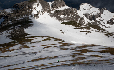 silueta de personas subiendo por una ladera de montaña