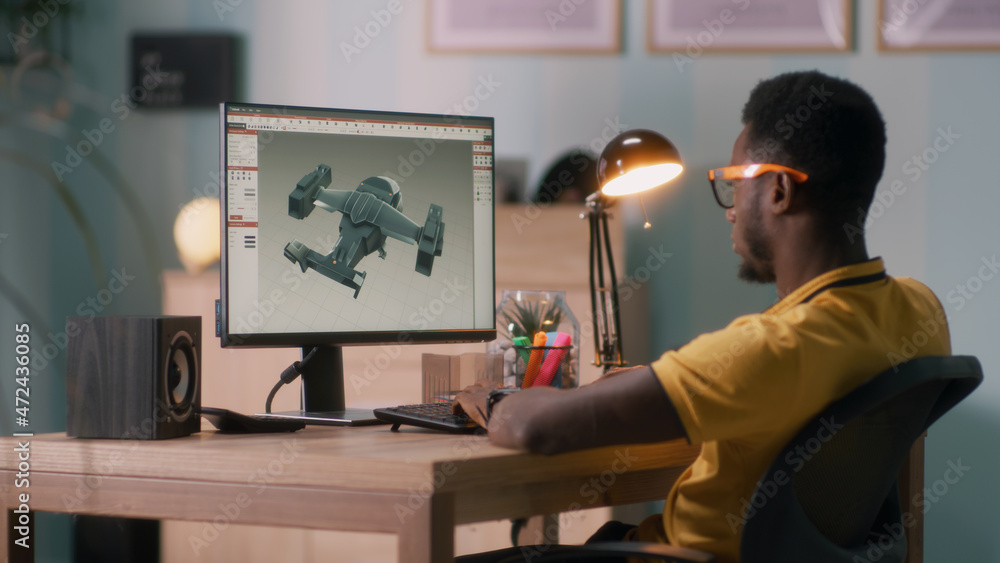 Poster african american man in glasses using computer to create 3d model of aircraft while working at home 