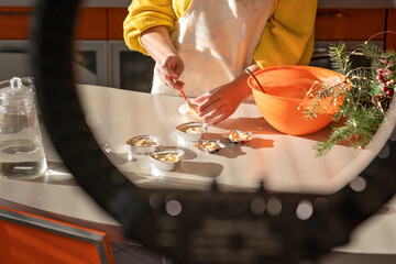 Girl in an apron prepares cupcakes in the kitchen