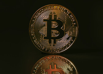 Bitcoin coin on black background with reflection.