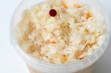 Close up of sour cabbage in the plastic bucket on white background.