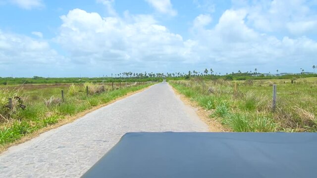 Passenger point of view on a buggy ride through a cobblestone side street on a sunny day, tourist view. Buggy ride at Porto de Galinhas, Ipojuca PE, Brazil.