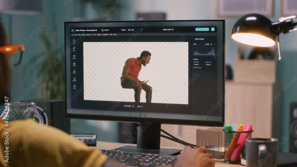 Poster black man adding 3d graphic into video with chromakey background while sitting at table and working 