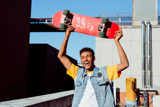 Handsome young black man with a skateboard on the street