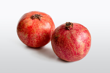 Fototapeta na wymiar Ripe red pomegranates on a light background
