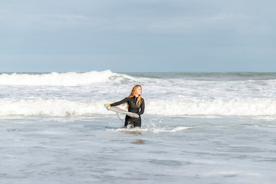 Woman with surfboard in sea