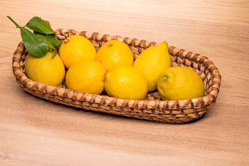 yellow lemons in a small wooden basket