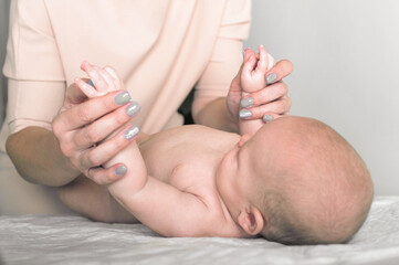 Newborn baby and mother's hands close up and copy space. Child 5 months old massage, colic, teething...