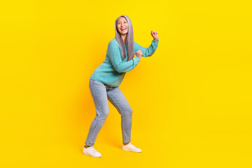 Fototapeta na wymiar Full length body size view of attractive cheerful modern grey-haired woman dancing resting isolated on bright yellow color background
