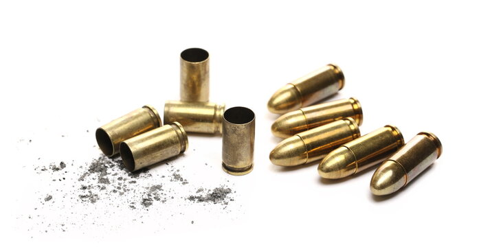 9mm pistol bullet casings with gunpowder pile isolated on white background